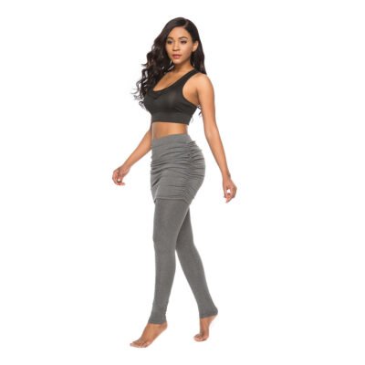 Model wearing full-length fitted leggings with a high waist and attached ruched mini-skirt overlay.