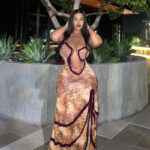 Model wearing a ruffle cutout maxi dress with a plunging front, delicate halter straps, ruched waist, and flowing floor-length skirt.