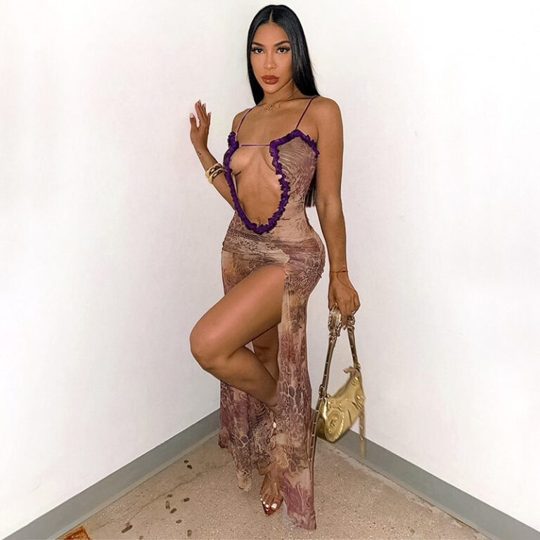 Model wearing a sheer mesh maxi dress with an ultra-deep plunge front, ruffle trim, asymmetric straps, and a high side slit.