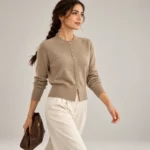 Women's beige button-down cardigan styled with cream wide-leg trousers in a full-length studio look.